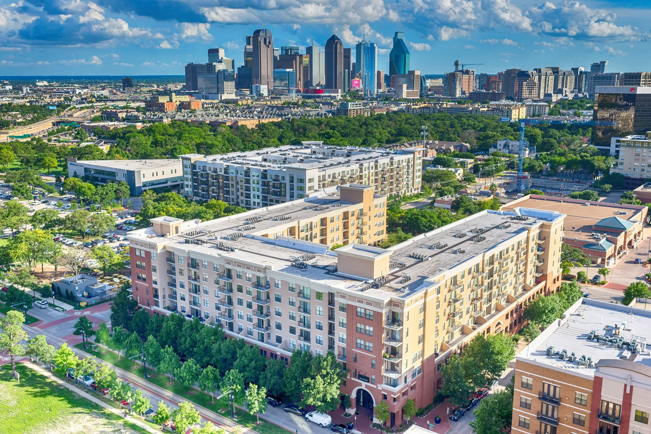 Aerial view of a Dallas apartment complex with the city skyline behind it