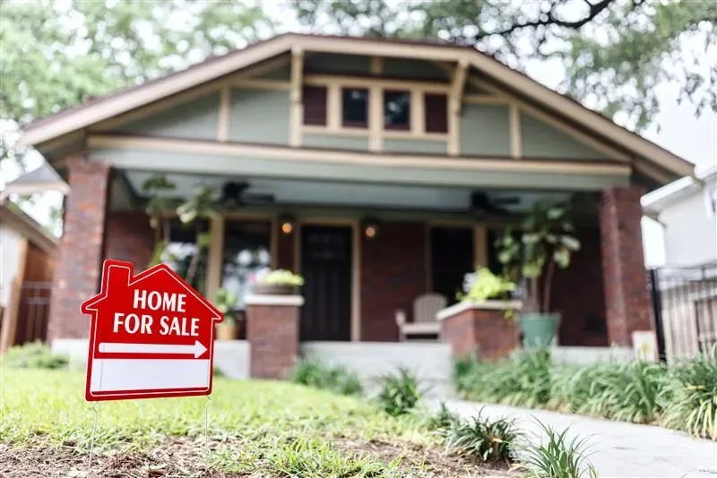 Home for sale sign in front of a house